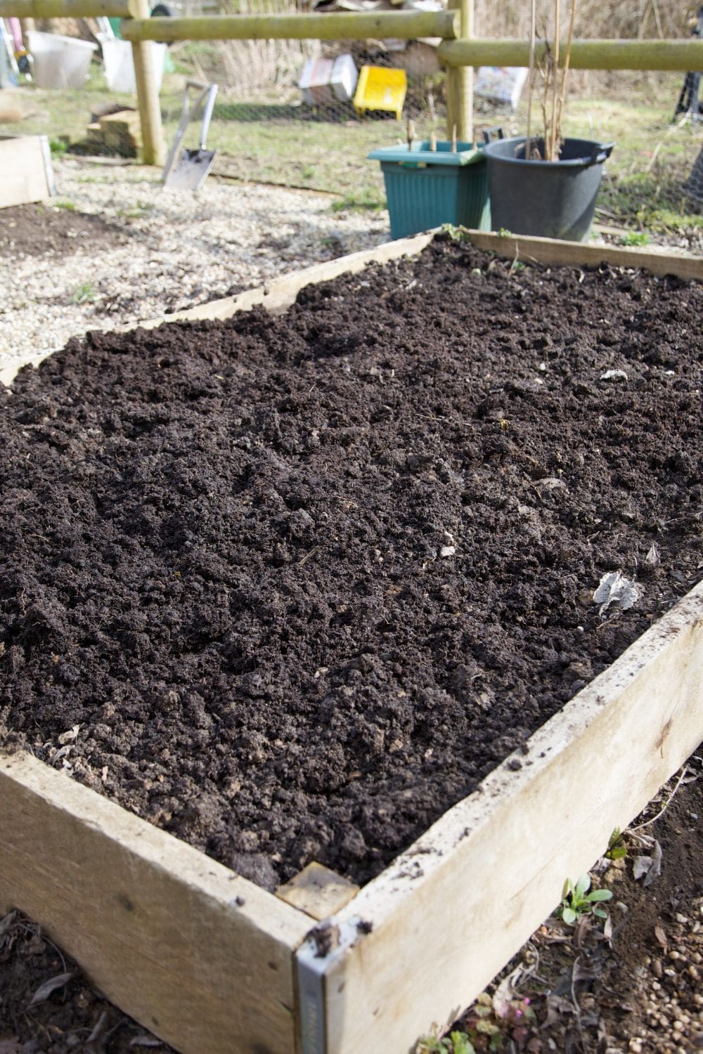 a garden bed that was filled with a smooth layer of dark nutrient rich soil 1